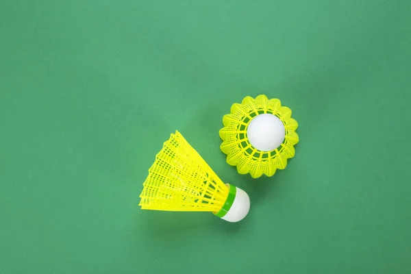 Two shuttlecock for badminton on a green background, top view. The concept of active breathing.