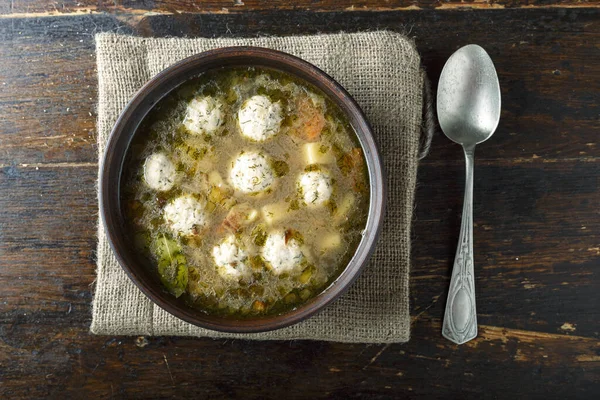 homemade soup with meatballs in a plate on the table. delicious hot lunc