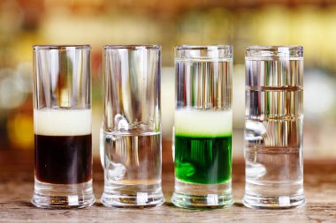 Çok katmanlı alkollü kokteyller tezgahın üzerinde, bir klozetin içinde sergilenir.