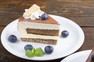 Yaban mersinli bir dilim pasta. Beyaz bir tabakta servis edildi..