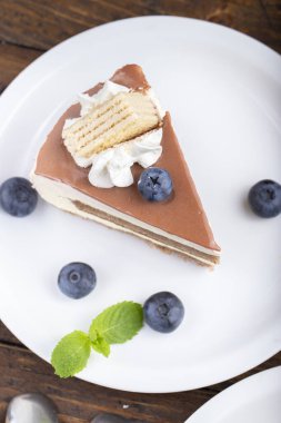 Yaban mersinli bir dilim pasta. Beyaz bir tabakta servis edildi..