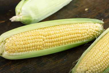 Tahta masadaki koçanlarda taze mısır, yakın plan, üst manzara.