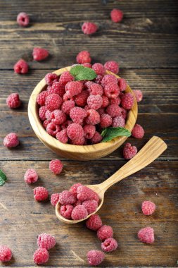 Masanın üzerinde, kahverengi ahşap arka planda olgun çiftlik böğürtlenleri hasadı