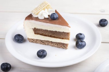 Masadaki tabakta bir dilim çikolata ya da kahveli kek. Holida için lezzetli bir ikram.