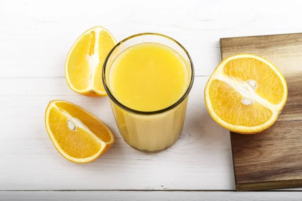 fresh orange drink in a glass and sliced orange on the table. vitamin drink for breakfas