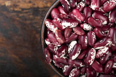 Ahşap bir arka planda çiğ, mor fasulye yakın plan. tex için yer