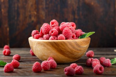 Tahta arka planda ahududu, basit bir ahşap tabakta. organik yaz cro