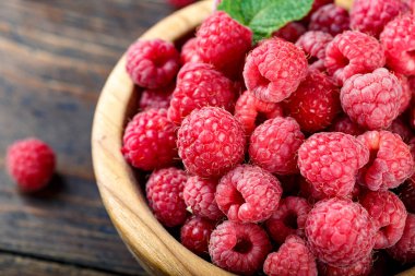 Tahta arka planda ahududu, basit bir ahşap tabakta. organik yaz cro