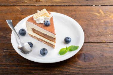 Masadaki tabakta bir dilim çikolata ya da kahveli kek. Holida için lezzetli bir ikram.