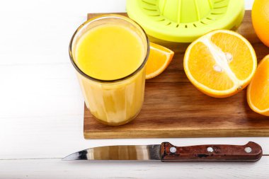 Tahtada taze portakallar ve meyve suyu. Ev yapımı portakal suyu.