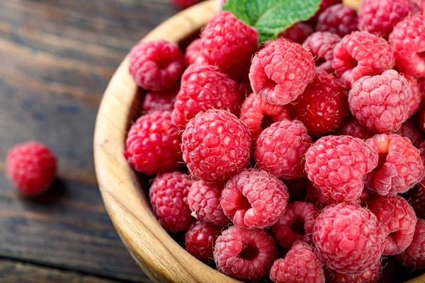 Tahta arka planda ahududu, basit bir ahşap tabakta. organik yaz cro