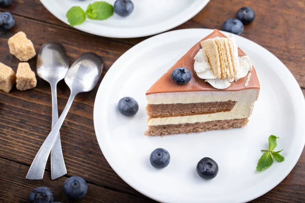 Yaban mersinli bir dilim pasta. Beyaz bir tabakta servis edildi..