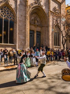 Valencia, İspanya. Mart 2018 civarı. Geleneksel sokak danslarında gösteri yapan bir grup genç. Lonja de la Seda 'nın cephesi, Arkaplanda Meta Borsası Binası.
