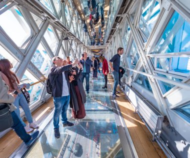 Londra, Birleşik Krallık. Ekim 2019 civarı. Thames nehri üzerinde cam zemini olan Tower Köprüsü 'nün içini ziyaret eden turistler.