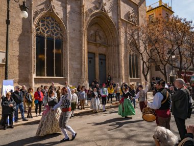 Valencia, İspanya. Mart 2018 civarı. Geleneksel sokak danslarında gösteri yapan bir grup genç. Lonja de la Seda 'nın cephesi, Arkaplanda Meta Borsası Binası.
