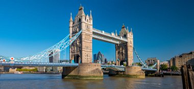 Güneşli bir günde Thames nehri üzerindeki Tower Köprüsü 'nün panorama manzarası. Şehir Finans Bölgesi gökdelenleri ve Londra Kulesi arka planda..