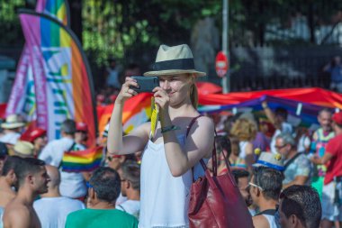 Madrid, İspanya. Temmuz 2017 dolaylarında. Madrid 'de eşcinsel yürüyüşünde turist fotoğraf çekiyor.