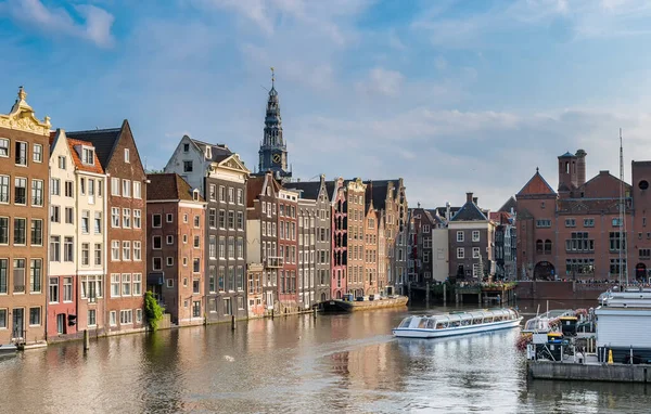 Beroemde huizen naast de kanalen en toeristenboten in Amsterdam, Nederland — Stockfoto