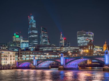 Arkasında Southwark köprüsü ve finans bölgesi olan Thames nehrinin gece manzarası. Londra şehri, Birleşik Krallık