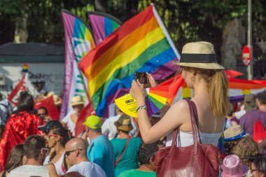 Madrid, İspanya. Temmuz 2017 dolaylarında. Madrid 'de eşcinsel yürüyüşünde turist fotoğraf çekiyor.