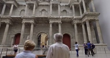 Berlin, Almanya. Mayıs 2018. Pergamon Müzesi 'ndeki Miletus Pazar Kapısı' nı ziyaret eden turistler. Sinematik kamera hareketi.