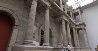Berlin, Almanya. Mayıs 2018. Pergamon Müzesi 'ndeki Miletus Pazar Kapısı' nı ziyaret eden turistler. Sinematik kamera hareketi.