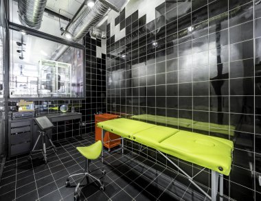 Siyah kiremitleri ve yeşil yatağı olan parlak bir masaj odası manzarası. Dövme stüdyosu modern stüdyo işi