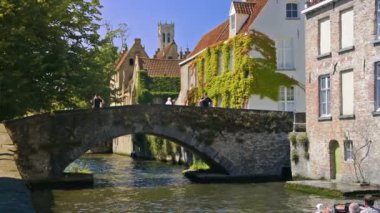 Bruges, Belçika. Ağustos 2016 dolayları. Güneşli bir günde bina ve kanalların şehri, arka planda çan kulesi.