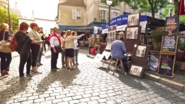 Paris, Fransa. Aralık 2017. Montmartre mahallesini ziyaret eden turistler, boyacı caddesi. Ressamlar resim satıyor. Yavaş çekim.