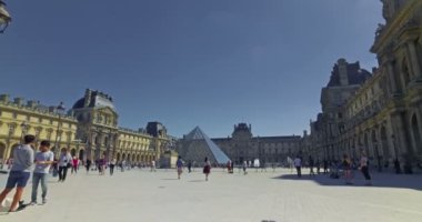Paris, Fransa. Ağustos 2017. Günbatımında Louvre Müzesi 'nin önünde turistler. Dolly kamera hareketi.