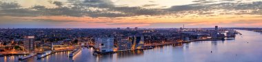Kanallardaki aydınlatılmış köprülerin panoraması geceleri. Amsterdam şehri, Hollanda Alacakaranlıkta