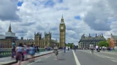 Londra, Birleşik Krallık. Temmuz 2017 dolaylarında. Güneşli bir günde Westminster Köprüsü 'nde ve Big Ben' de aşırı hız yapan insanlar..