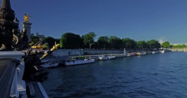Alexander II köprüsünden Seine nehrinin panoraması. Turist teknesi ve gezinti alanındaki insanlar..