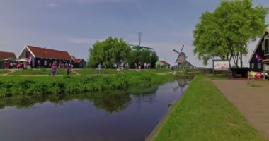 Zaanse Schans, Hollanda. Ekim 2017. İnsanlar yel değirmenlerini ve çiftlik köyünü ziyaret ediyor. Sinematik kamera hareketi.