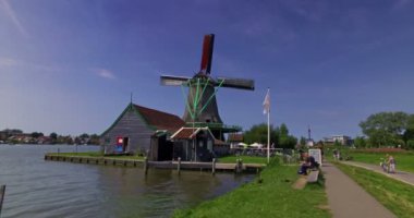 Zaanse Schans, Hollanda. Ekim 2017. İnsanlar yel değirmenlerini ve çiftlik köyünü ziyaret ediyor. Sinematik kamera hareketi.