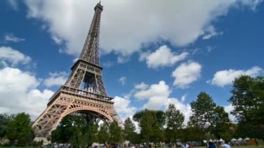 Güneşli bir günde Eiffel kulesinin yanındaki parkta dinlenen turistlerin zamanaşımı,
