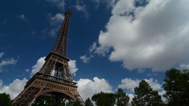 Včasná doba Eiffelovy věže s mraky za slunečného dne.