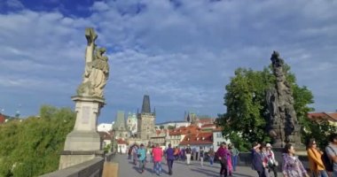 Güneşli bir günde Charles Köprüsü 'nü ziyaret eden turistler. Arka planda Prag Kalesi ve Saint Vitus Katedrali var. Prag, Çek Cumhuriyeti