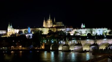 Gemi yolculuklarının ve Charles Köprüsü 'nün gece süreleri. Arka planda Prag Kalesi ve Saint Vitus Katedrali.
