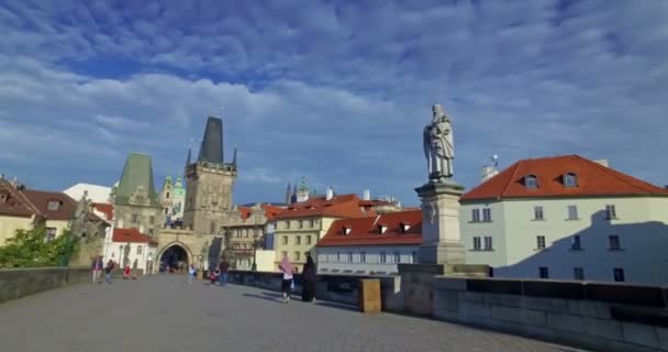 A turisták ellátogatnak a Károly hídra egy napsütéses napon. Prágai vár és Szent Vitus katedrális a háttérben. Prága, Cseh Köztársaság — Stock videók