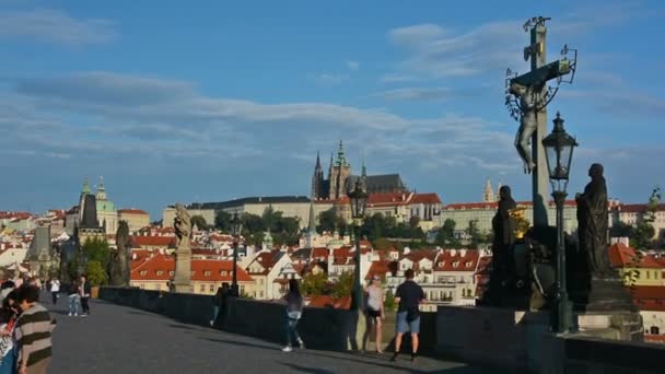Güneşli bir günde Charles Köprüsü 'nü ziyaret eden turistler. Arka planda Prag Kalesi ve Saint Vitus Katedrali. — Stok video
