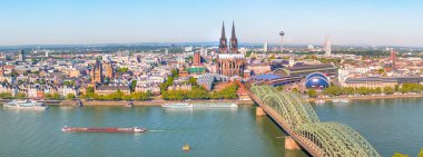 Güneşli bir günde Ren nehri üzerindeki Hohenzollern Köprüsü 'nün hava manzarası. Köln, Almanya 'nın güzel şehirleri. Arkasında katedral ve büyük St. Martin Kilisesi var.