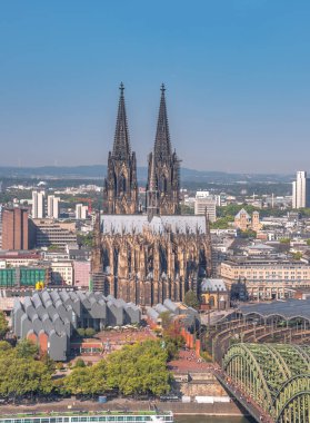 Güneşli bir günde Ren nehri üzerindeki Hohenzollern Köprüsü 'nün hava manzarası. Köln, Almanya 'nın güzel şehirleri. Arkasında katedral ve büyük St. Martin Kilisesi var.