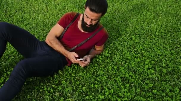 Young Confident Bearded Man Using His Phone Grass Park — Stock Video