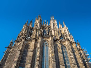 Güneşli bir günde Almanya 'nın Köln kentindeki Gotik Aziz Peter Katedrali. Kulelerin, kemerlerin ve pencerelerin detaylarıyla güzel bir şehir manzarası