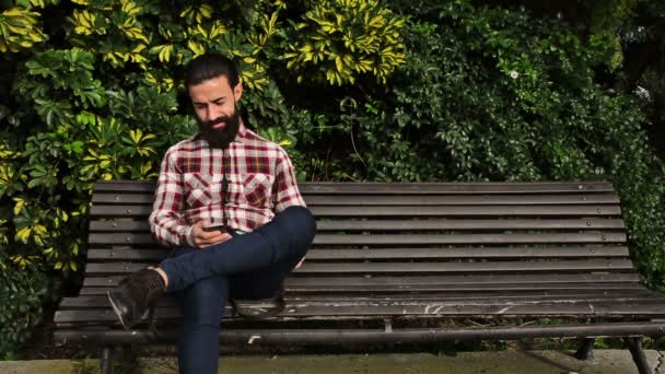 Junger Selbstbewusster Bärtiger Mann Benutzt Sein Handy Einem Park — Stockvideo