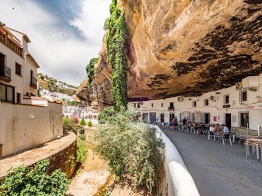 Setenil de las Bodegas, İspanya. Temmuz 2018 civarı. Rio Trejo 'nun yukarısındaki mağaralarda kayalara dönüştürülmüş evlerdeki restoranlar