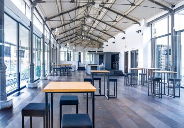 Gent, Belçika, Ağustos 2019 dolaylarında. Modern parlak güzellik en az boş restoran. Yemek, kafeterya, siyah beyaz dekorlu iç mekan, uzun masalar, filaman lambaları ve beton zemin.