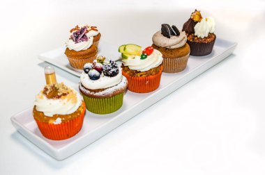 Lezzetli ve yaratıcı kekler, beyaz arka planda izole edilmiş.