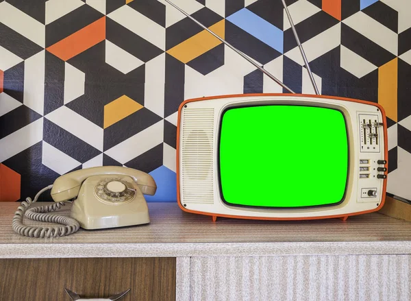 Retro televizyon arka planda antika telefon ve duvar kâğıdıyla modellenir. 70 'lerden kalma seramik dekorasyonlu şablon iç dekorasyonu